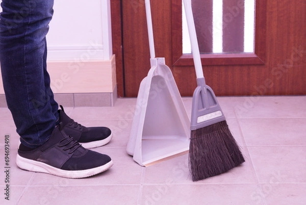 Obraz 玄関内にてほうきで掃除するアップ写真。ゴミ取り、掃除、清潔感、家事、管理をイメージ