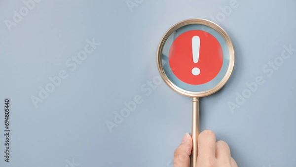 Fototapeta Attention caution warning concept. Magnifying glass focus on red page with exclamation error mark for important alert signal, Hazard, risk ,danger background with copyspace.
