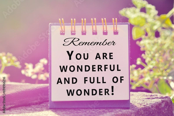 Fototapeta Motivational and inspirational quote on stand paper with beautiful sun ray.