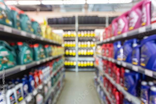 Obraz Blurred colorful motor oil bottles on shelves in specialized store.