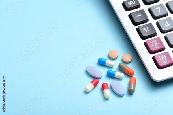 Obraz A pile of drugs placed next to the calculator on a blue background