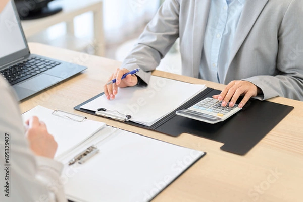 Fototapeta 見積もりの計算をするビジネスウーマン