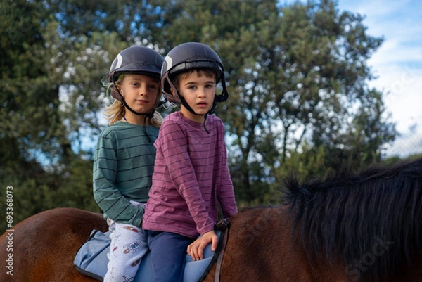 Obraz Two children riding a horse together