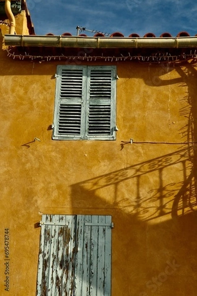 Fototapeta Window with shatters on the yellow wall