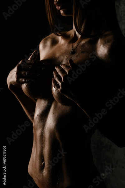 Obraz athletic figure without underwear of a sexy girl belly with drops of sweat and water in the gym in a low key	