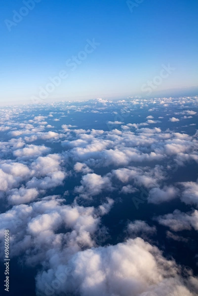 Fototapeta Top view of white fluffy clouds and clear sky above them