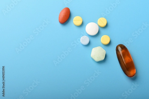 Obraz Concept of healthcare and medicine. Top view, copy space , Assorted pharmaceutical medicine pills, tablets and capsules. Close up of many different pills on blue background. Pills background. Free spa
