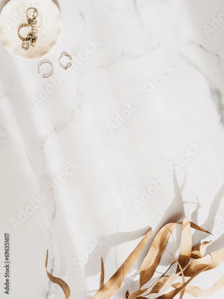 Fototapeta Minimal fashion frame with feminine accessories on a white marble dressing table with shadow
