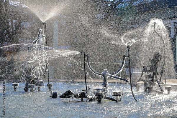 Obraz The Tinguely fountain in the city center Basel with partly frozen parts and splashing in backlit in cold winter weather