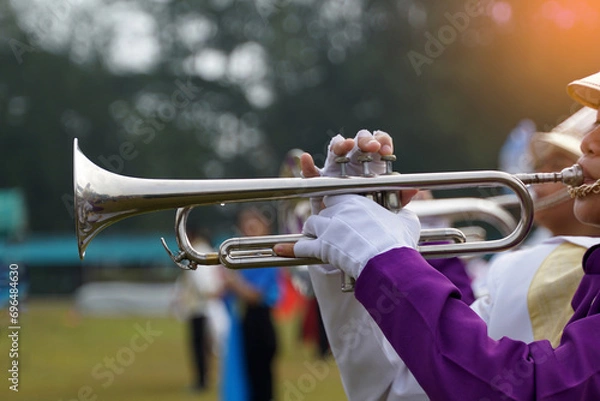 Obraz -	Close-up of student's hand pressing the button of a trumpet to chase a musical note, playing a song while practicing for a school parade. Soft and selective focus. 