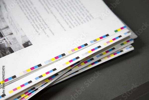 Obraz White sheets with with the text and paint around the edges are stacked in a printing house. An abstract background of sheets of paper.