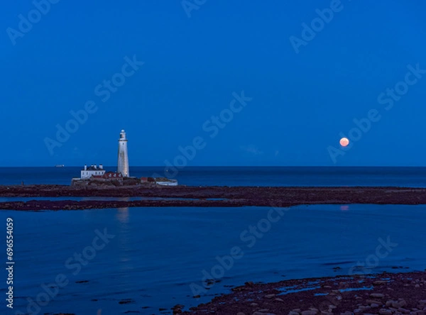 Fototapeta St Marys Island and lighthouse with moon and copy sace.