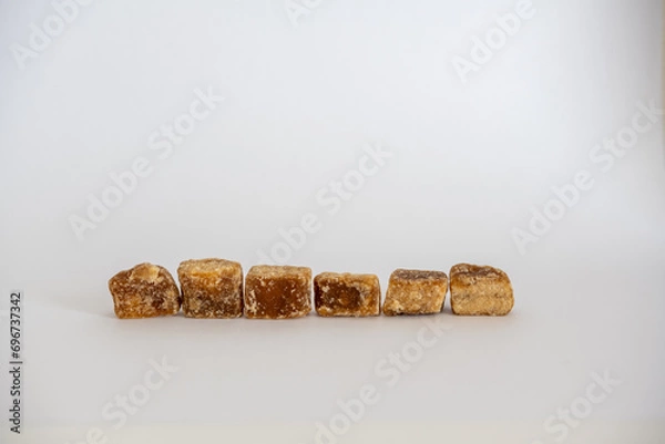 Obraz 黒糖の塊一列置き白背景