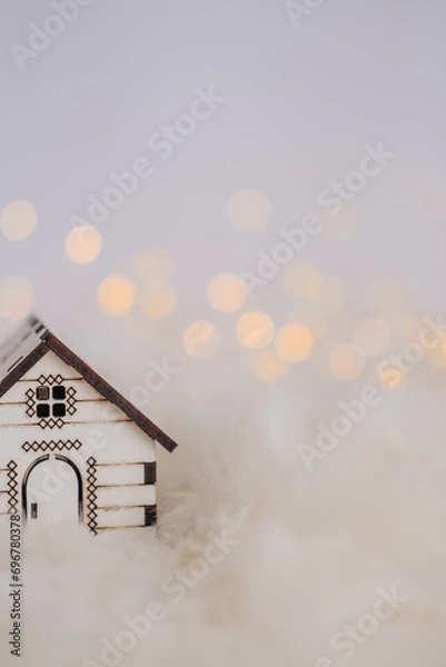 Fototapeta Miniature wooden house on white fur background with bokeh lights