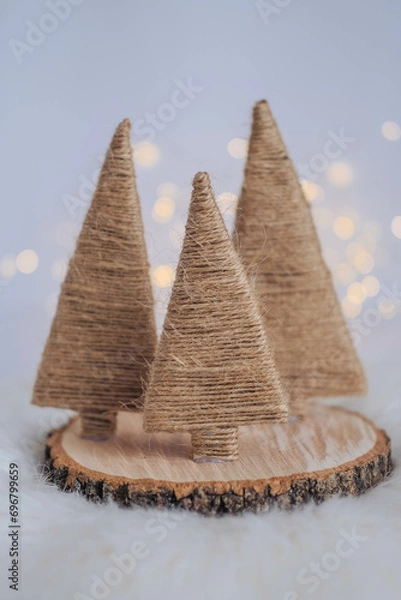 Fototapeta Christmas tree made of straw on a white background with bokeh.