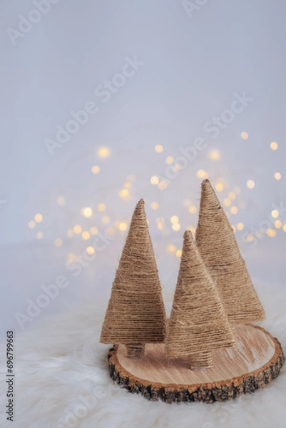 Fototapeta Christmas tree made of straw on a white background with bokeh.