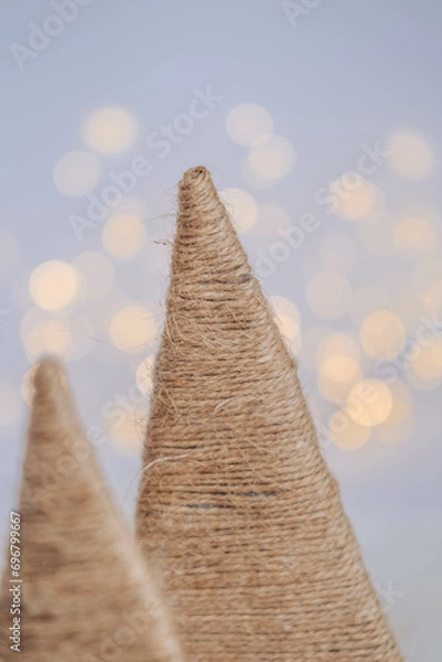 Fototapeta Christmas tree made of straw on a white background with bokeh.