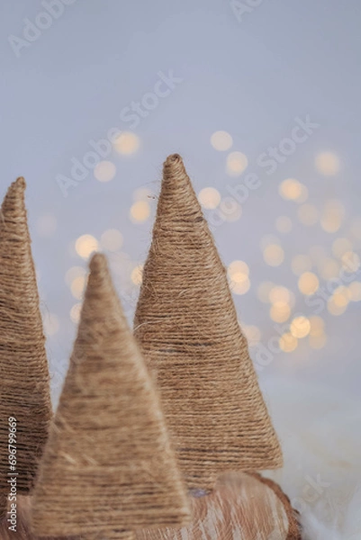Fototapeta Christmas tree made of straw on a white background with bokeh.