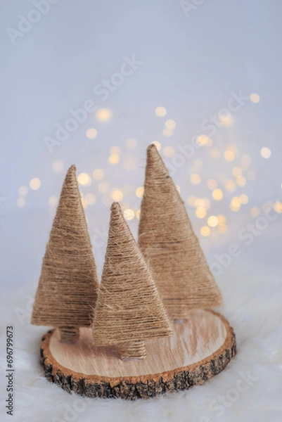 Fototapeta Christmas tree made of straw on a white background with bokeh.