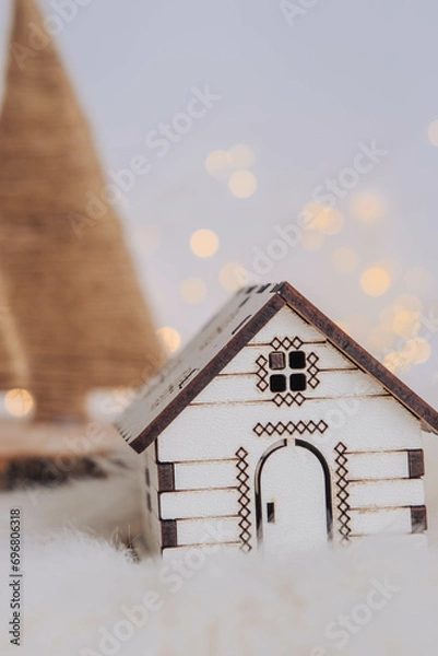 Fototapeta Small wooden house with christmas tree and bokeh background.