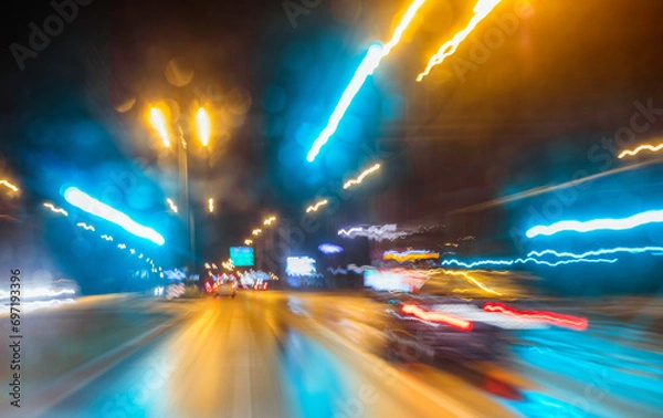 Fototapeta City colorful night lights perspective blurred by high speed of the car. A streak of light, trails.