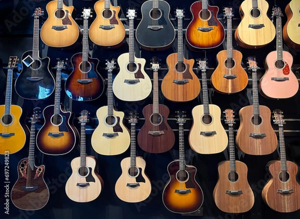 Obraz a wall full of acoustic guitars of different models and types of wood, guitars store, guitars hanging in a wall,  horizontal