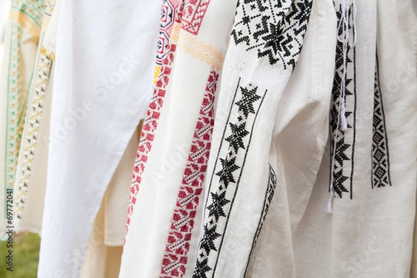 Obraz white textile shirts with colored ethnic folk patterns