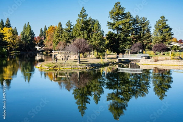 Fototapeta Dramatic image of the man made lake in Marysville, California, with reflections and fall colors in the trees.