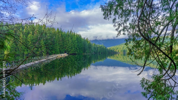 Fototapeta Float bridge on Sasamat Lake in Belcarra Provincial Park as viewed from Sasamat Loop forest trail on a bright winter day.