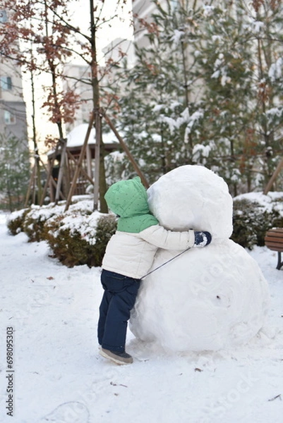 Fototapeta child loves snowman