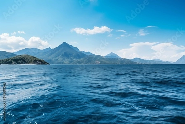 Fototapeta A large lake surrounded by mountains reflects the sky and clouds