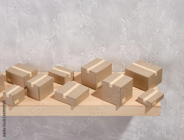 Obraz Pattern of cardboard boxes on a gray background. Copy space for text. Composition of move and relocation.