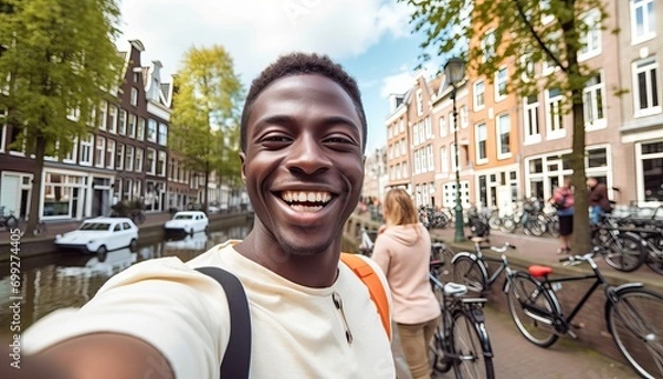 Fototapeta Happy tourist taking selfie picture in Amsterdam, Netherlands , Cheerful man using smart mobile phone device outside , Student traveler enjoying summer european vacation , Life style tourism