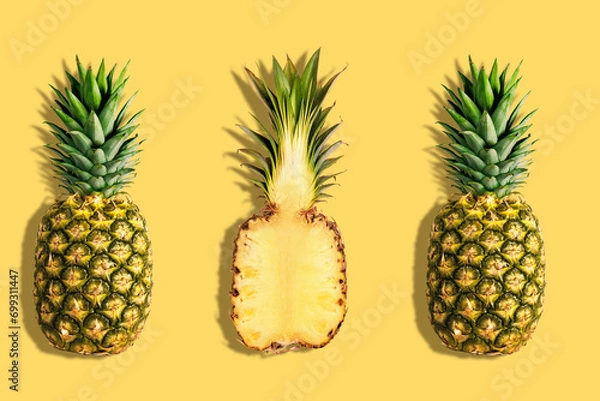 Obraz Fresh pineapples on yellow background. Creative suumer concept.