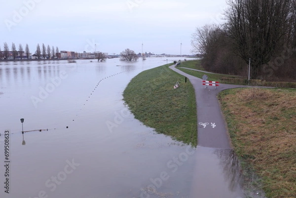 Obraz Flooding of the river Rhine, Arnhem, the Netherlands, bike path is not accessible because of the high water level. The water reaches the dike.