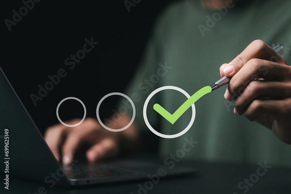 Obraz Businessman checking mark and takes online assessment survey test for approve quality assurance and ERP management, Quality management with assurance.
