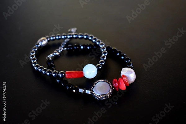 Fototapeta A set of beaded bracelets on a black background