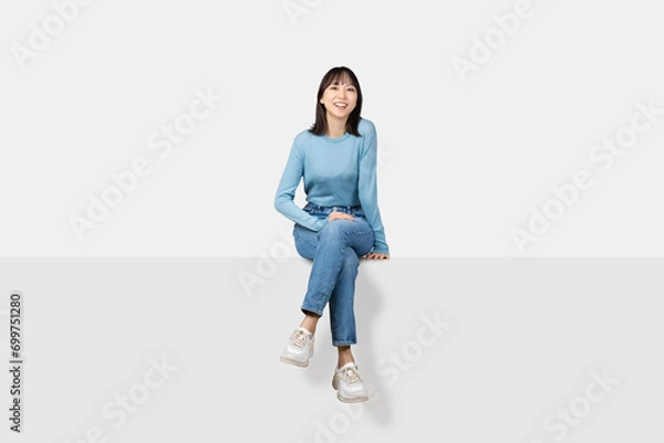 Obraz 足を組んで腰掛ける笑顔の女性