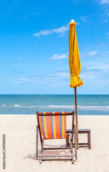 Fototapeta Colorful beach chair and closed umbrella on beautiful beach with