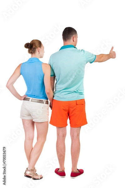 Fototapeta young couple pointing at wal Back view