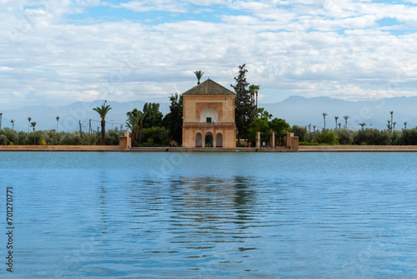 Obraz Photo of the Menara Gardens in the city of Marrakech. Photo of the lake with the house at the end of the lake. The house reflected in the lake. Cloudy day.