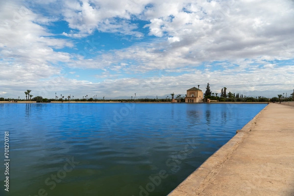Obraz Photo of the Menara Gardens in the city of Marrakech. Photo of the lake with the house at the end of the lake. The house reflected in the lake. Cloudy day.
