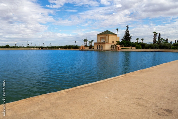 Obraz Photo of the Menara Gardens in the city of Marrakech. Photo of the lake with the house at the end of the lake. The house reflected in the lake. Cloudy day.