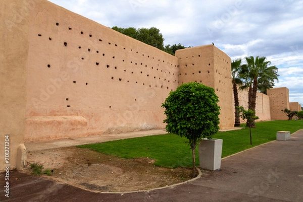 Obraz Photo of the city walls of Marrakech. Walls with holes for pigeon nests. Cloudy day.