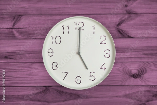 Fototapeta Five o'clock. Time management or business concept. Plain white wall clock showing 5 pm on a wooden background. End of working day. Opening or closing hours. Schedule or working, study hours.