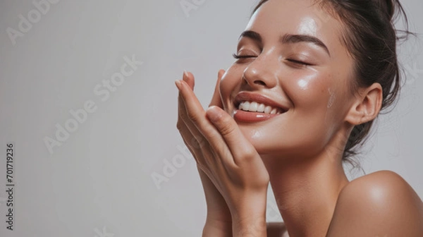 Obraz Skincare. Woman with beautiful face touching healthy facial skin. Woman smiling while touching her flawless glowy skin with copy space for your advertisement, skincare