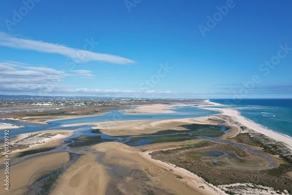 Fototapeta aerial drone view of climate in praia da fuseta in algarve portugal with fields, lakes and beach next to the atlantic ocean and nature