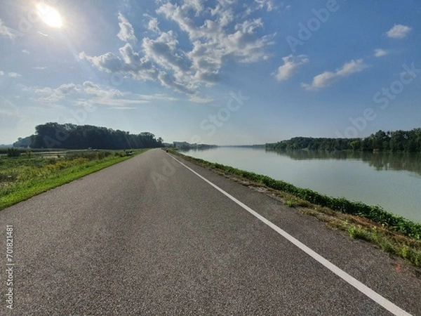 Fototapeta Amazing bike path near river on a sunny day in austria. Famous Donauradweg next to beautiful danube river in austria. Copy space for text. Travel and holidy concept