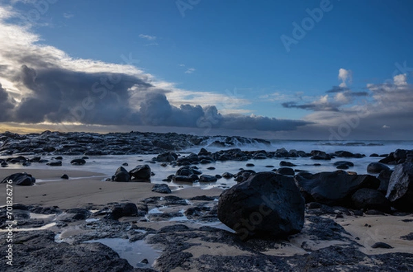 Fototapeta Long exposure view of waves crashing on the rocky shore of Benares beach located on the south coast of Mauritius island	