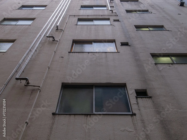 Obraz 雑居ビルの窓と配管と外壁